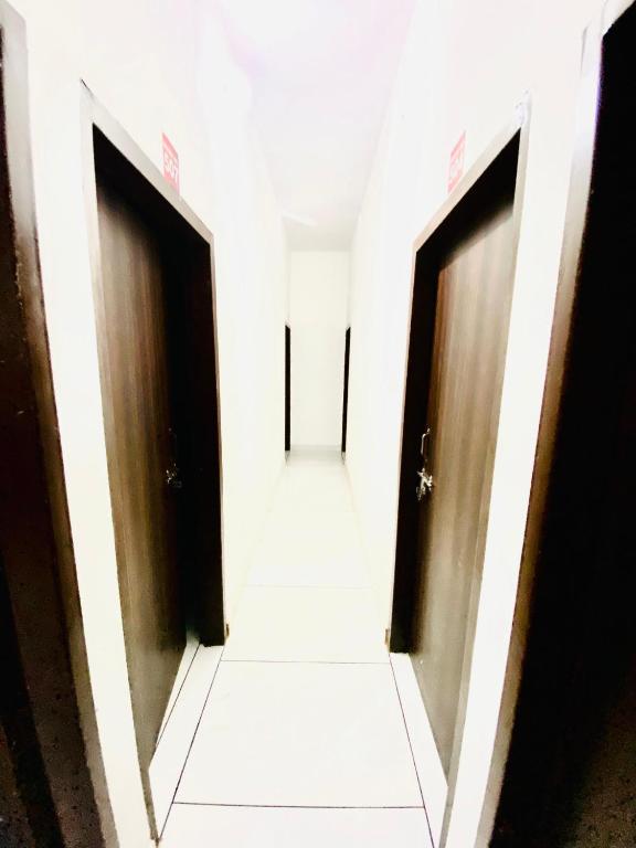 a corridor with two doors in a building at Dh Hotel in Bhiwāni