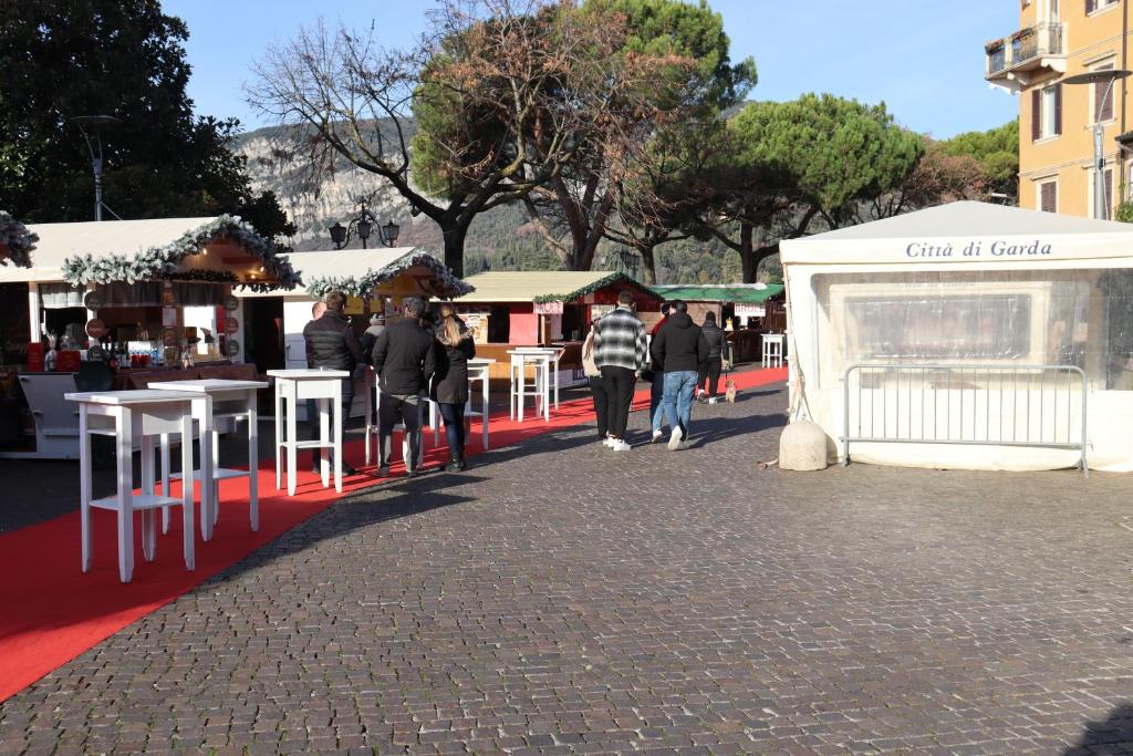 un gruppo di persone che camminano su un tappeto rosso con tavoli di Monika Holiday Beautiful Lake View Lovely a Garda