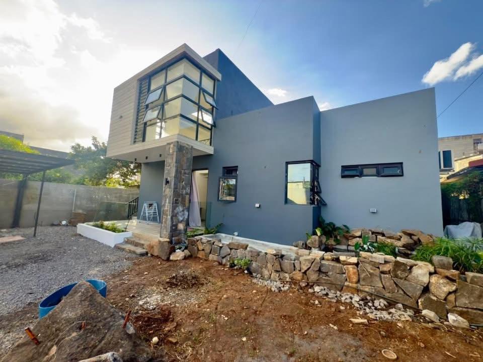 een blauw huis met een stenen steunmuur bij LS maison de vacance in Roche Bois
