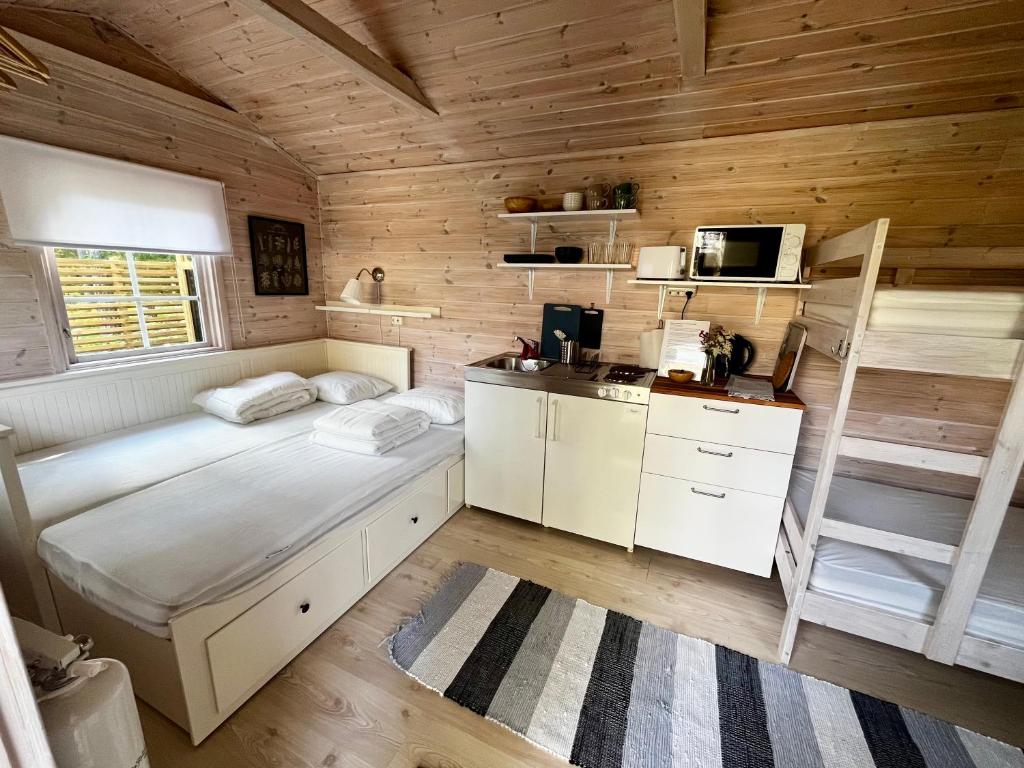 une chambre avec deux lits, un bureau et un micro-ondes dans l'établissement Karamellgårdens stuga, à Herräng