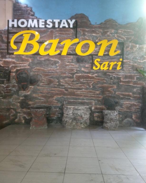 a brick wall with a sign for a baron seminar at Baron Sari Homestay in Pulau Kukup