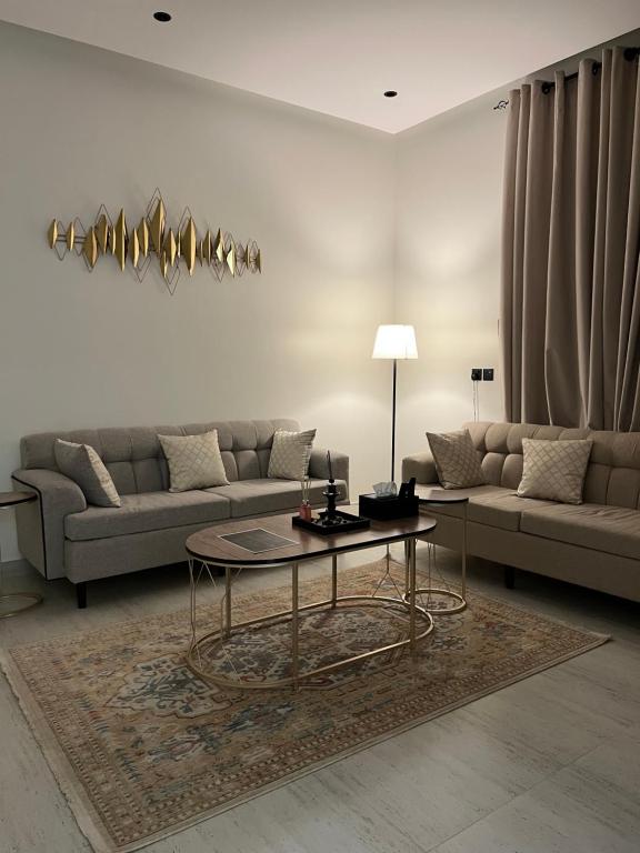 een woonkamer met een bank en een tafel bij SUKN Qiddiya- Al Muzahimiyah in Riyad