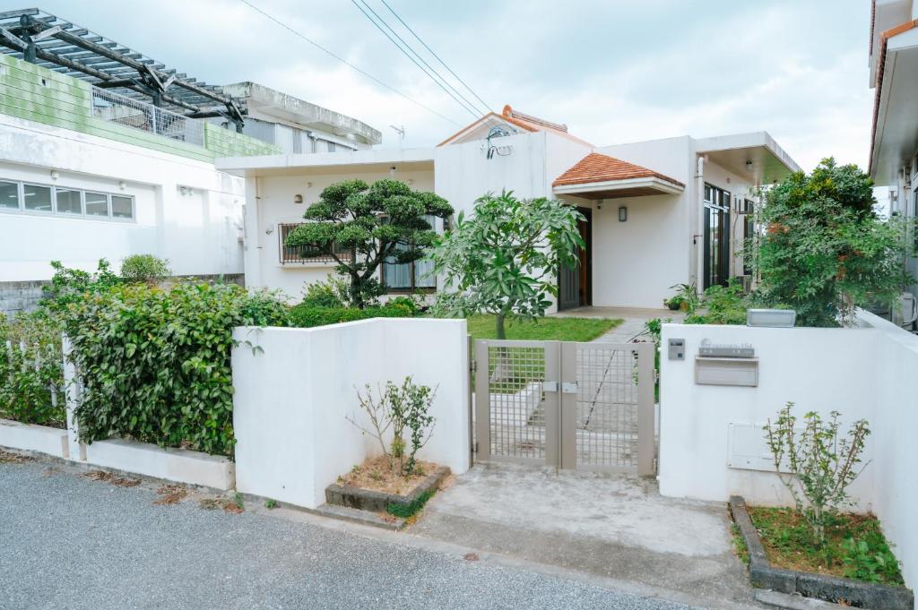 a white fence in front of a house at Nagoya in Nakijin