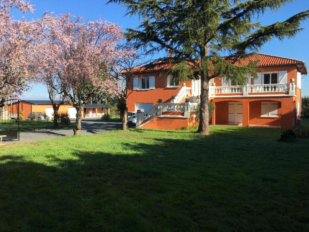 een huis met een tuin met bomen ervoor bij Escale et Séjour in Lavaur