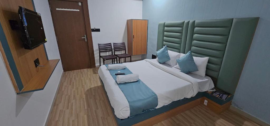a bedroom with a large bed and a television at Hotel Jalsa in Surat
