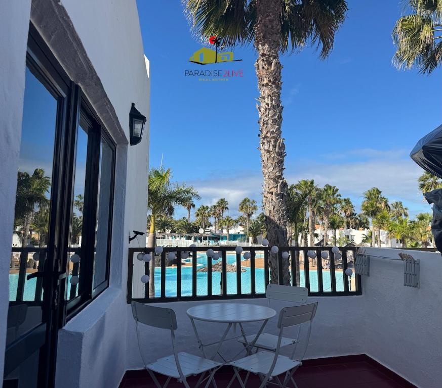 a table and chairs on a balcony with a view of the beach at Casa Dudu in Corralejo