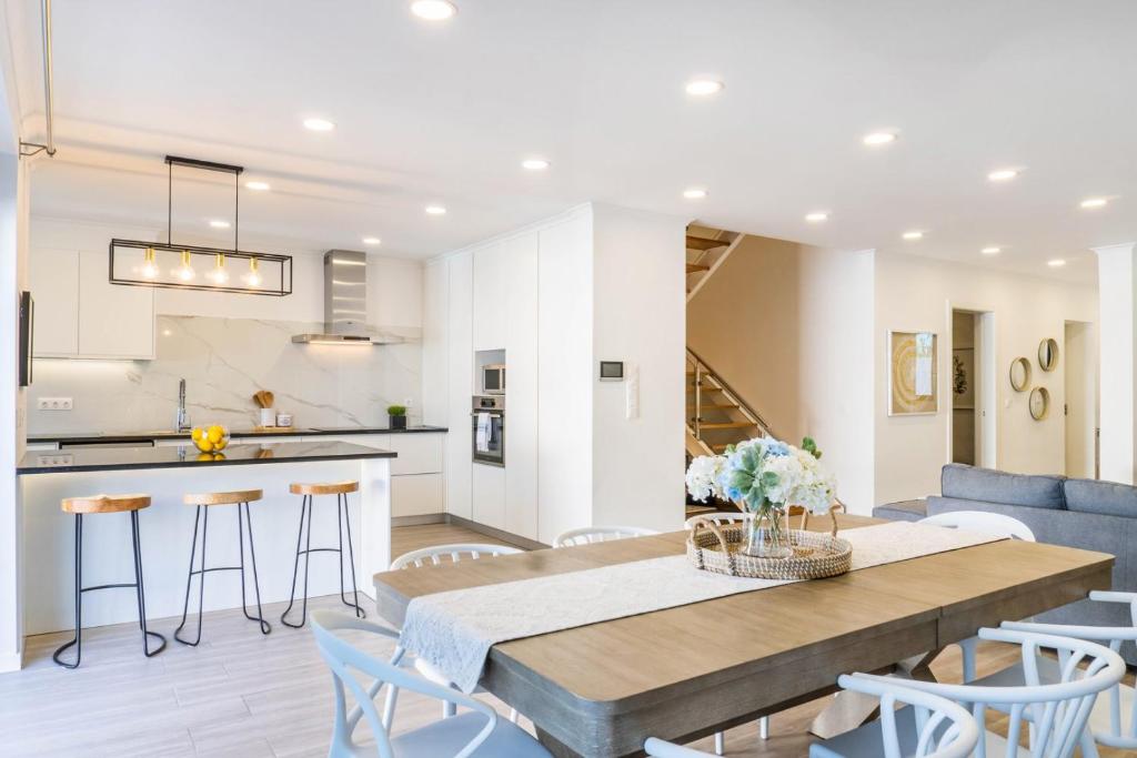 una cucina e un soggiorno con tavolo e sedie in legno di LUX House a Ponta Delgada