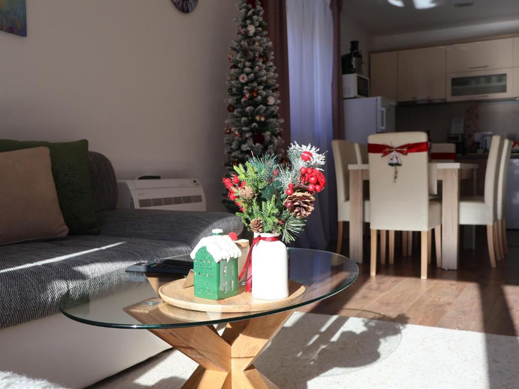 a living room with a table and a christmas tree at Durmitor Sunstone in Žabljak