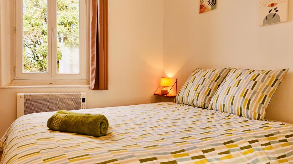 ein Schlafzimmer mit einem Bett und einem Kissen darauf in der Unterkunft Dréo - Spacieux avec terrasse in Brignoles