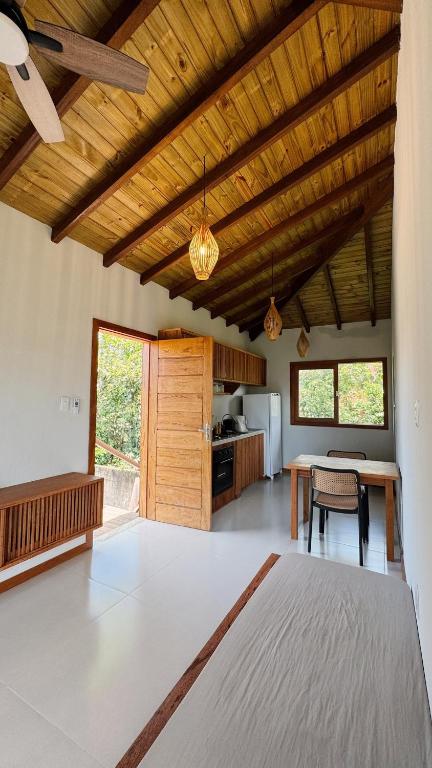 a living room with a table and a kitchen at Vila Baião - Casa Luiz Gonzaga in Itacaré