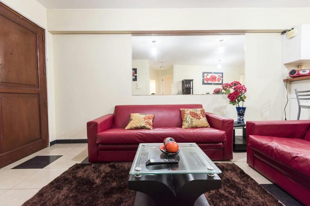 sala de estar con sofá rojo y mesa en Apartamento Edificio Pardo Cinco, en Lima
