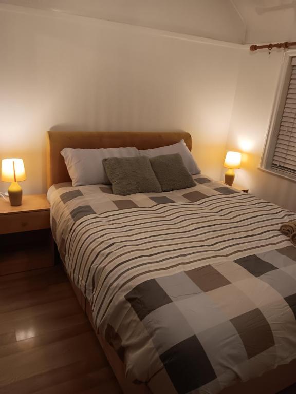 een slaapkamer met een groot bed met twee lampen bij High class accommodation in Bury