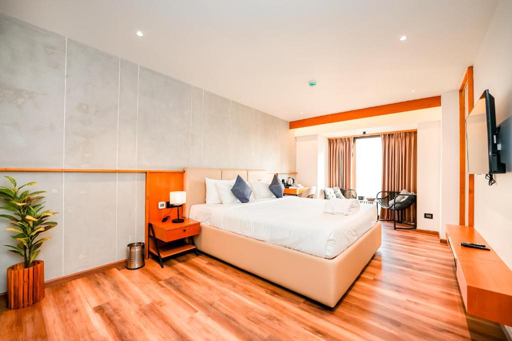 a hotel room with a bed and a tv at Nestlay Suites by TC One in Kozhikode