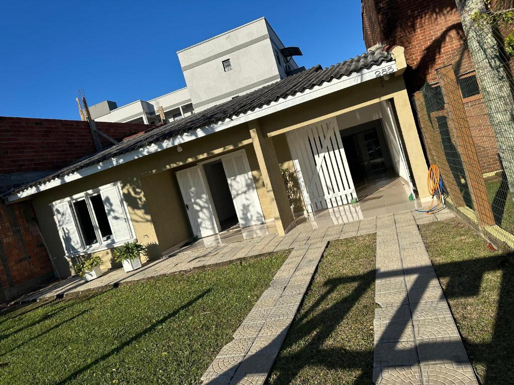 een huis met een gazon ervoor bij Conforto a 100 m do mar in Tramandaí