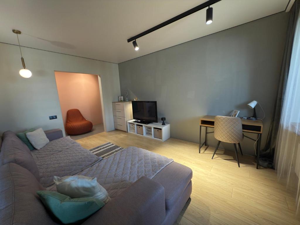 a bedroom with a bed and a desk and a table at 2 room Modern Apartment View in Dnipro