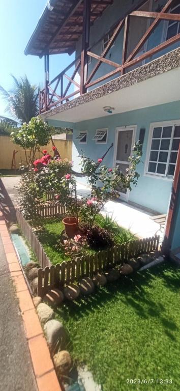 a garden in front of a house with a fence at Jardim Caribenho in Arraial do Cabo