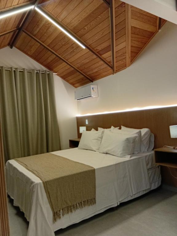 une chambre avec un grand lit avec des plafonds en bois dans l'établissement Loft Nápoles, à Santa Teresa