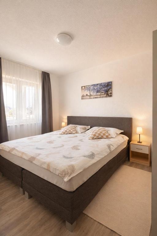 a bedroom with a large bed with two pillows at Apartman Mila in Golubić