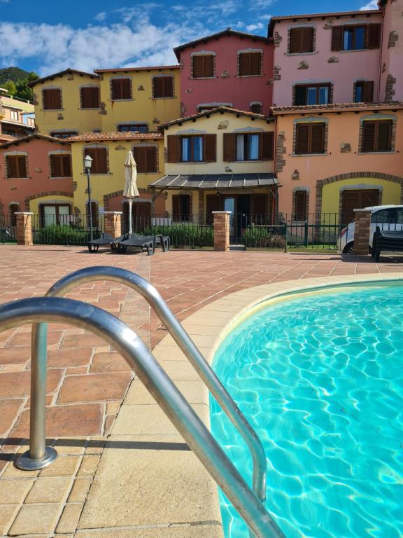 a swimming pool in front of some buildings at Aligia Chalet in Nebida