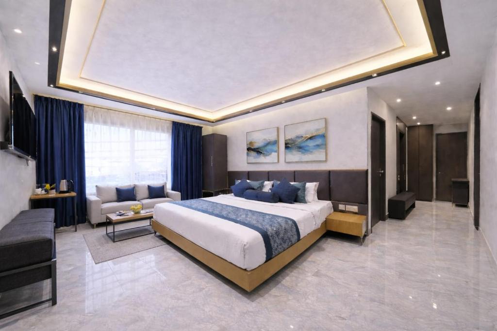 una camera da letto con un letto grande e un soggiorno di Hotel Vivanta Residency Delhi Airport a Nuova Delhi