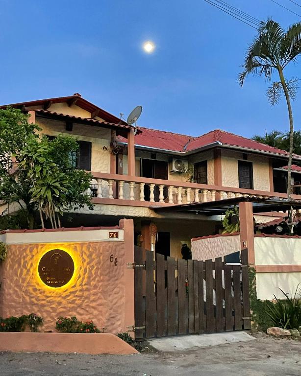 a house with a wooden fence in front of it at Suites e Casa_Pauba in São Sebastião