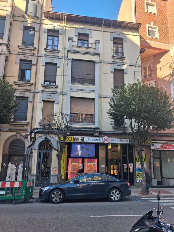een auto geparkeerd voor een gebouw in een straat bij Roma 8 in León