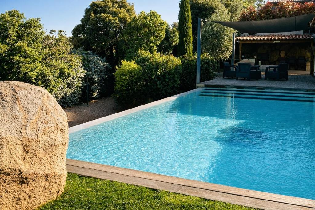 une piscine avec des chaises dans une cour dans l'établissement Villa Porto-vecchio 4 chambres avec piscine, à Porto-Vecchio