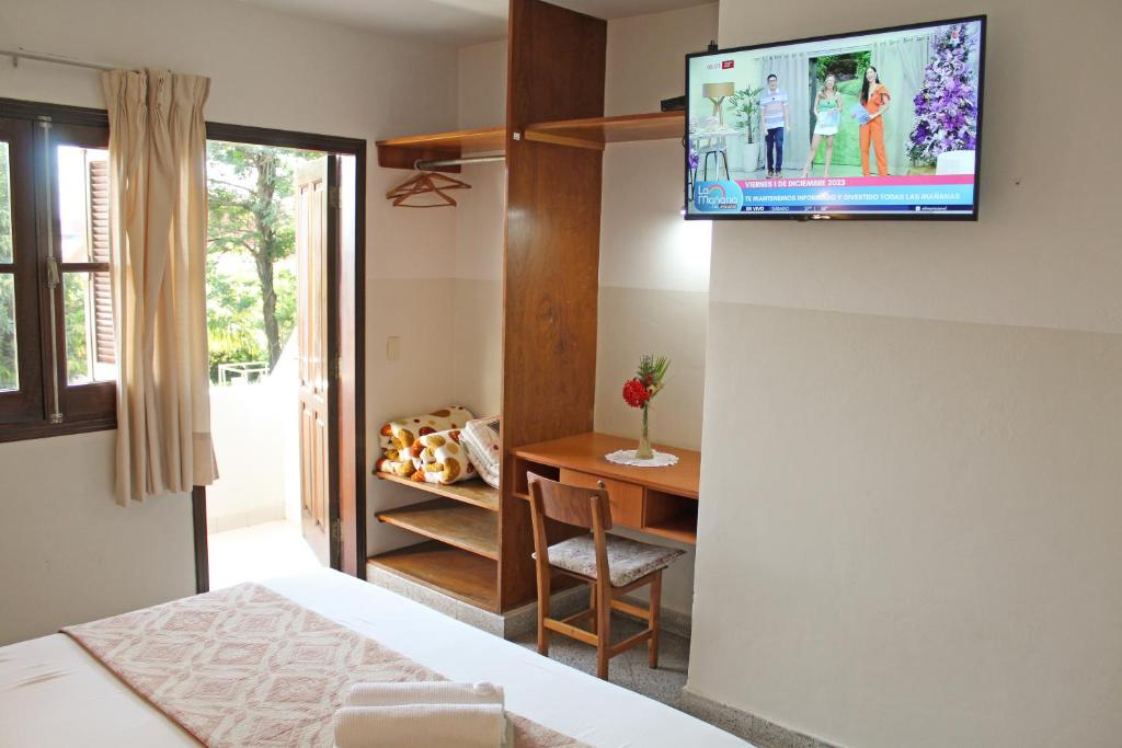 a room with a bed and a television on a wall at Das Heim Hotel in Asuncion