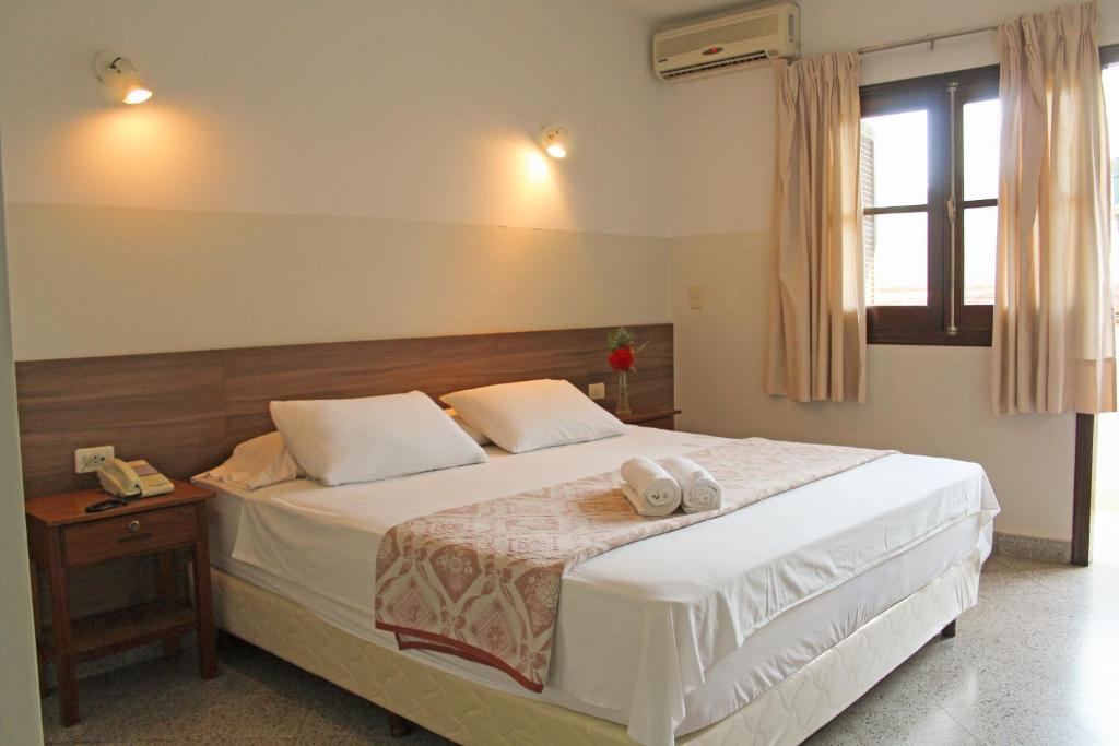 a bedroom with a bed with two towels on it at Das Heim Hotel in Asunción