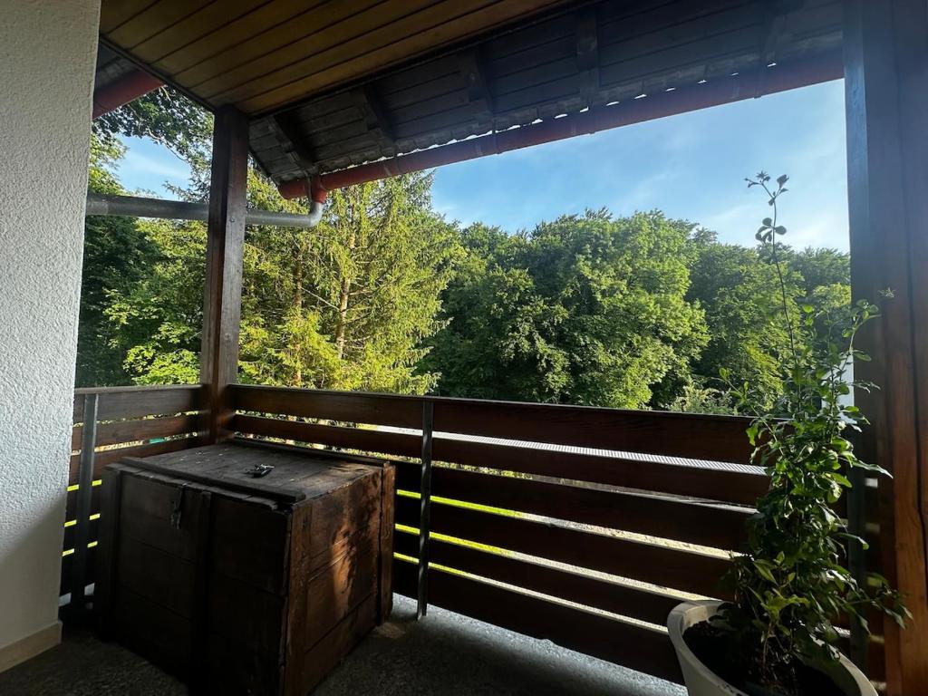 a porch with a large window looking out at trees at Waldhaus in Affing