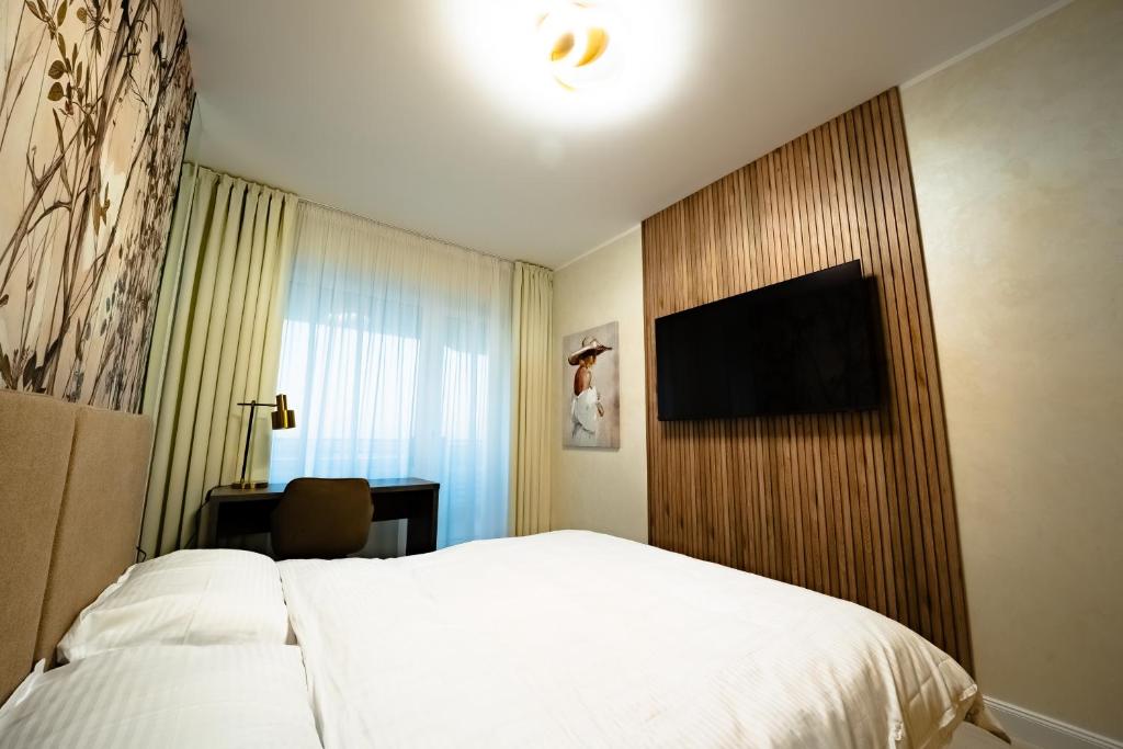 een hotelkamer met een bed en een flatscreen-tv bij Royal Luxury Suit in Iaşi