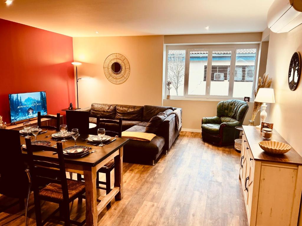 ein Wohnzimmer mit Sofa und Tisch in der Unterkunft Comme chez soi - Emplacement #1 et Grand Confort in Feurs