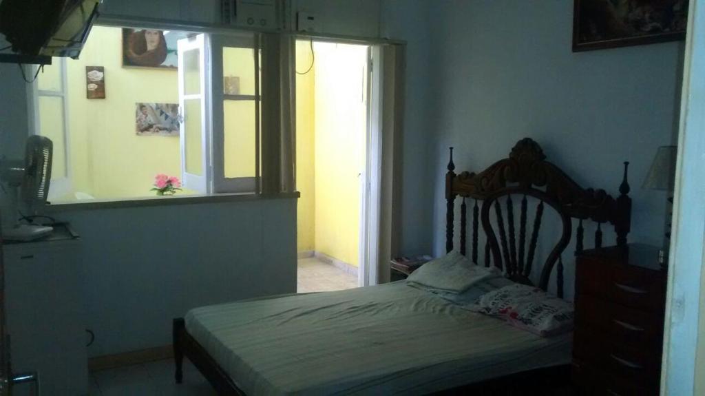 een slaapkamer met een bed in een kamer met een raam bij Casa da Gorett in Salvador