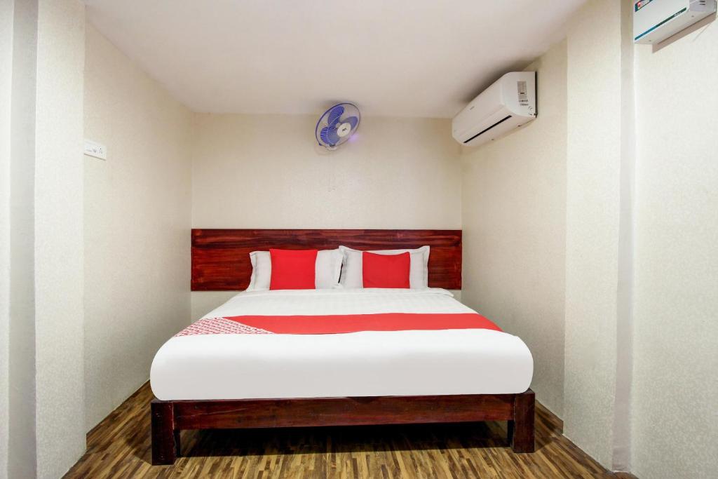 a bedroom with a large bed with red pillows at Super Hotel O Am Grandd in Tiruchchirāppalli