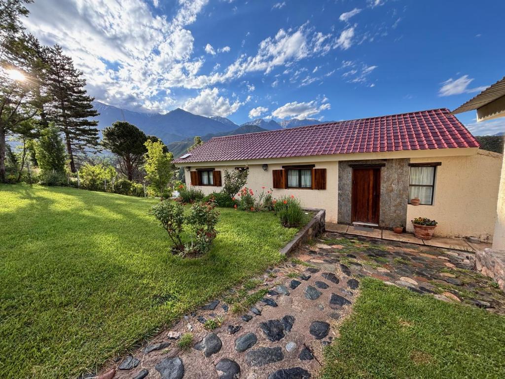 a house with a red roof on a green yard at El Mirador in Potrerillos