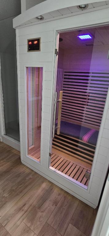 a room with a large window with purple lighting at Gîte avec sauna in Vigneux-de-Bretagne