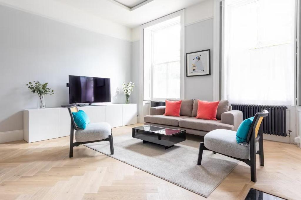 ein Wohnzimmer mit einer Couch und zwei Sesseln in der Unterkunft Metro Luxe Suites in Porto Cervo