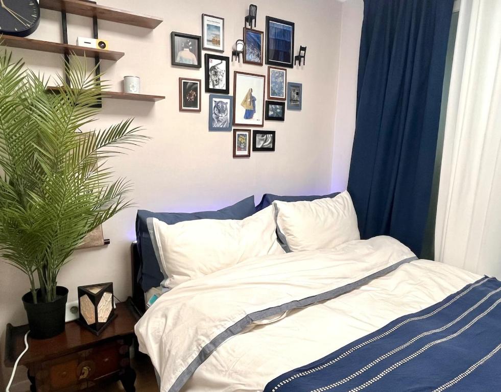 une chambre avec un lit et des tableaux au mur dans l'établissement Kintex Golden Stay, 
