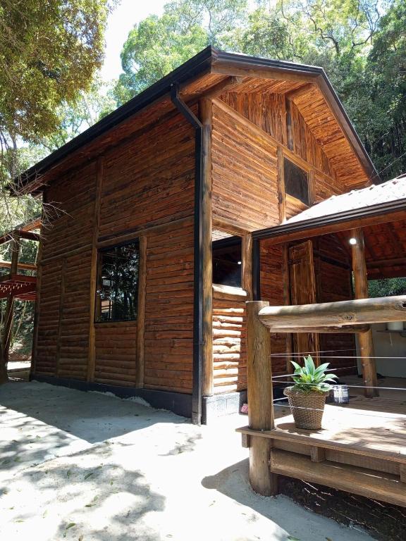 een houten hut met een bank ervoor bij Cabana Montana in Córrego do Bom Jesus