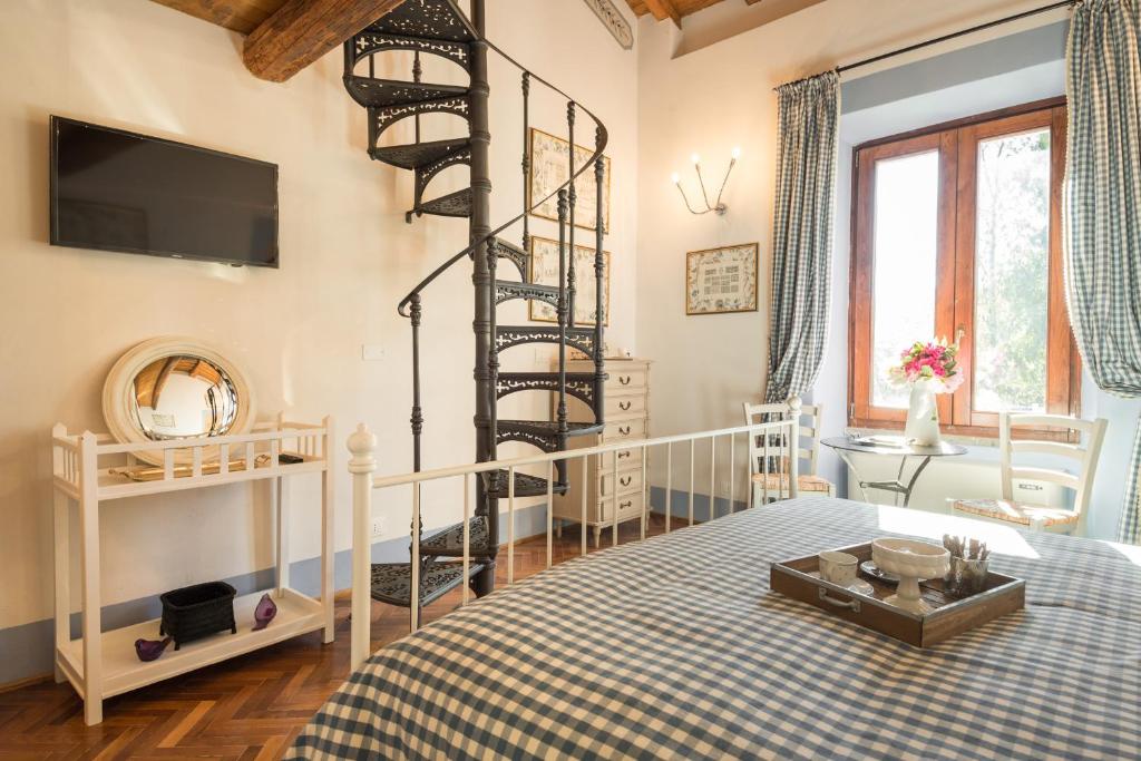 1 dormitorio con 1 cama y escalera de caracol en La Locanda di Borghetto, en La Giustiniana