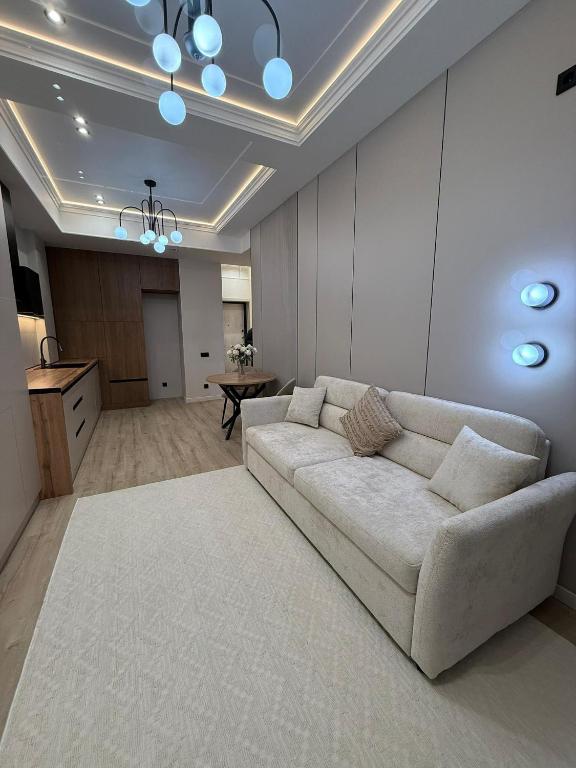 een woonkamer met een bank en een tafel bij doma24uz in Yakkasaray