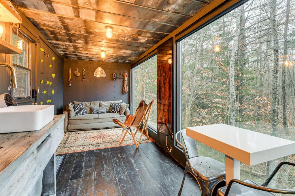 een keuken en woonkamer van een klein huis met een tafel en stoelen bij Secluded Red River Gorge Cabin with Rooftop Deck! in High Falls