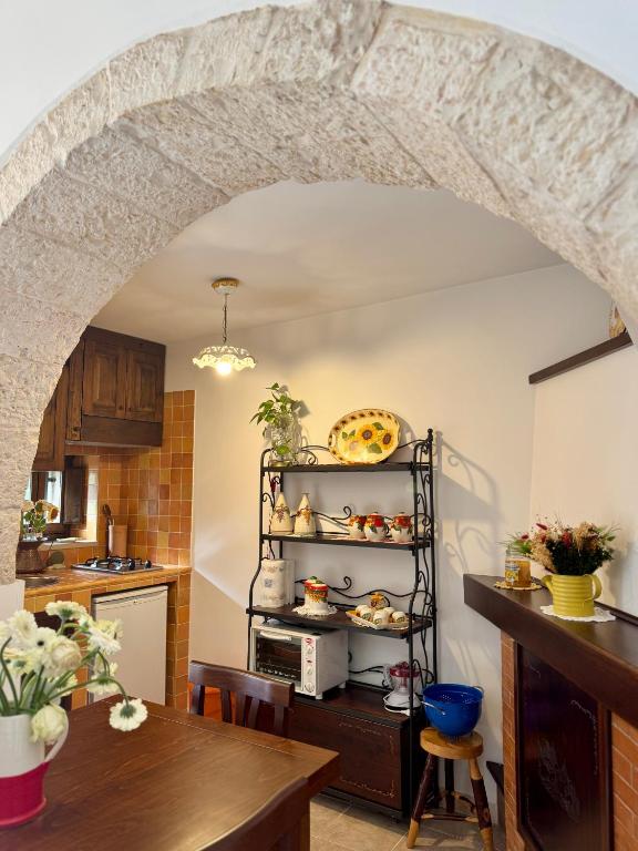 - une cuisine avec une arche au-dessus d'une table dans l'établissement Il Trullo Volza, à Locorotondo