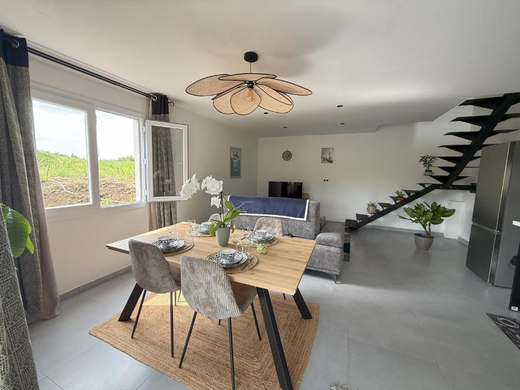 een woonkamer met een houten tafel en stoelen bij Le Plumeria in Saint-Pierre