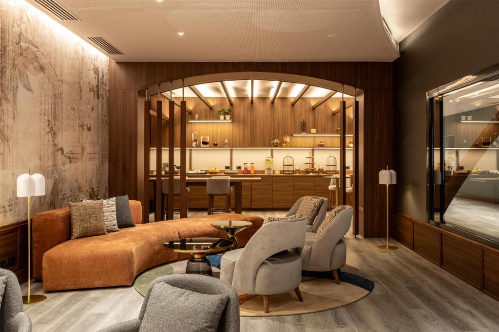 a living room with a couch and a table and chairs at Radisson Blu Hotel, Florence in Florence