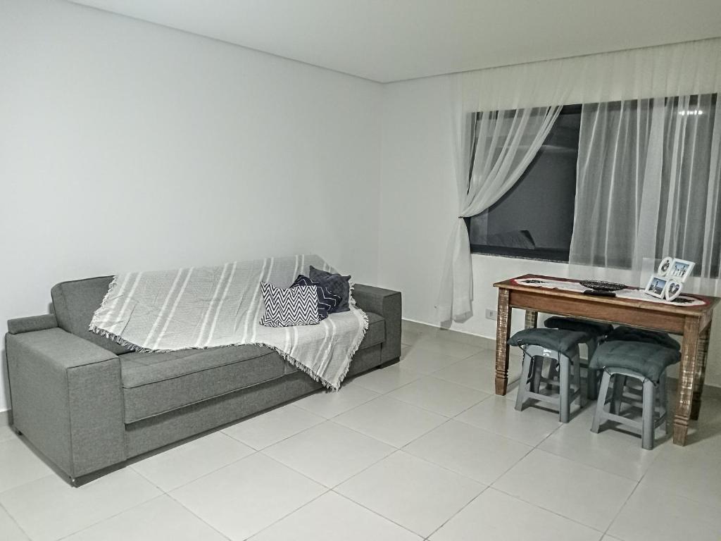 un salon avec un canapé, une table et une télévision dans l'établissement Casa das Cachoeiras, à Botucatu