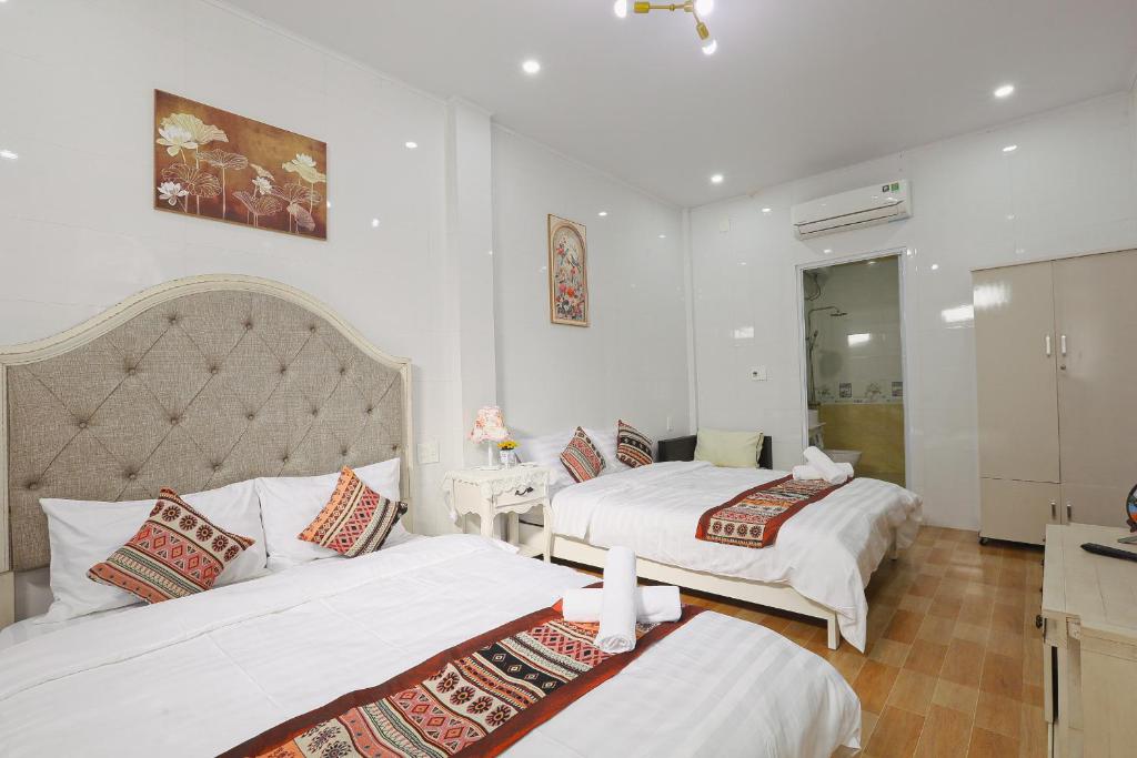 a hotel room with two beds and a bathroom at Huế Silk Homestay in Cồn Giả Viên