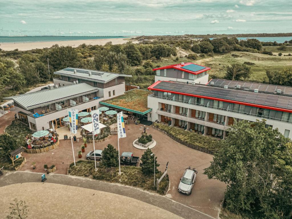 een luchtzicht op een hotel met een parkeerplaats bij Strandhotel Duinoord in Vrouwenpolder