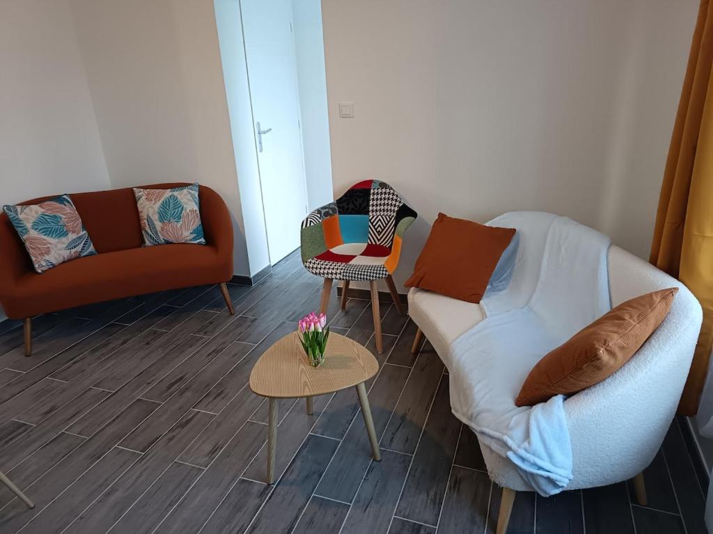 een woonkamer met een bank en een tafel bij Maison Le Platier d'Oye in Oye-Plage
