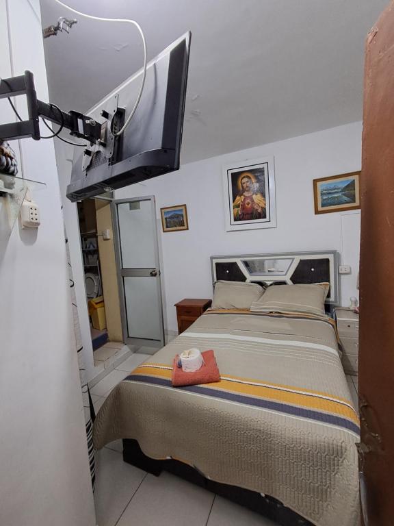 una camera da letto con un letto e una tv a parete di Hostal la familia a Churín